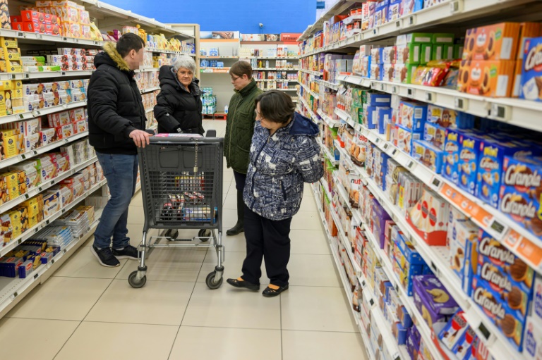 Sylvie Oswald (2eg) fait des courses dans un supermarché avec les personnes qu'elle accueille chez elle, le 25 février 2025 à Raon-l’Etape, dans les Vosges