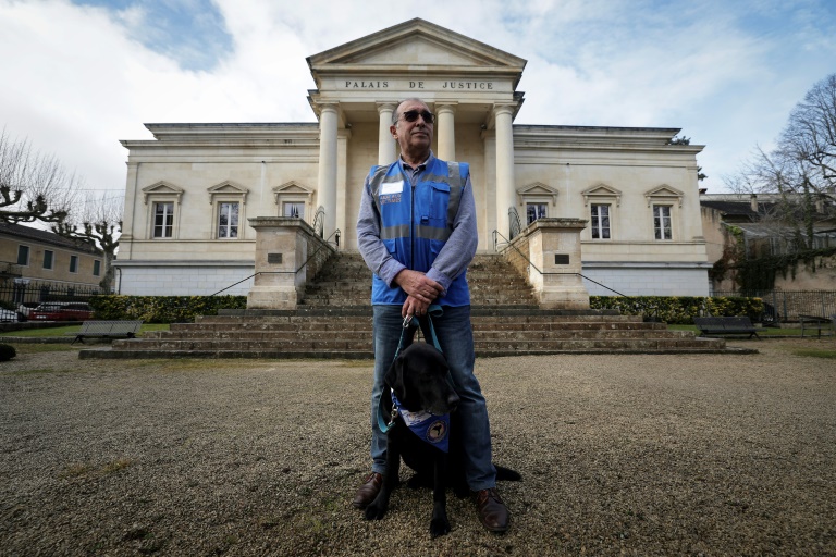 Jean-Marc Mir, bénévole de l'association France Victimes, et Lol, premier chien d'assistance jurdiciaire, devant le palais de justice de Cahors, le 14 février 2025 dans le Lot