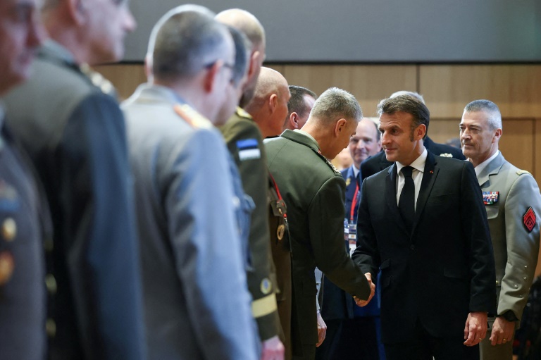 Le président Emmanuel Macron (c) serre la main des chefs d'état-major des armées de l'Union européenne et de l'Otan avant une réunion sur le conflit russo-iranien, le 11 mars 2025 à Paris