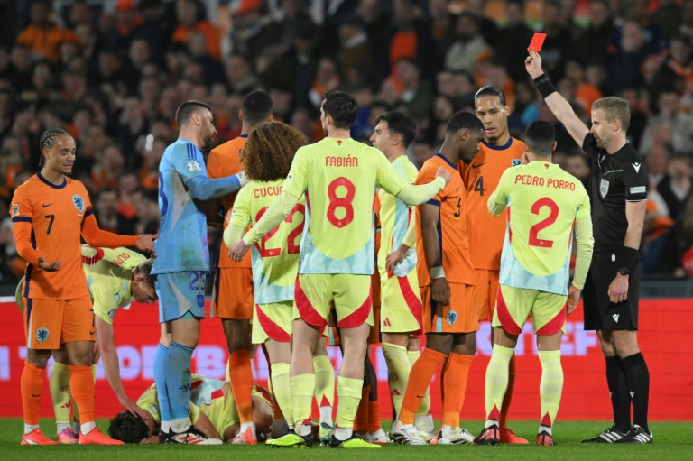 L'arbitre Glenn Nyberg expulse le joueur néerlandais Jorrel Hato (4e à droite) lors du match aller des quarts de finale de la Ligue des Nations entre les Pays-Bas et l'Espagne au stade De Kuip à Rotterdam le 20 mars 2025.