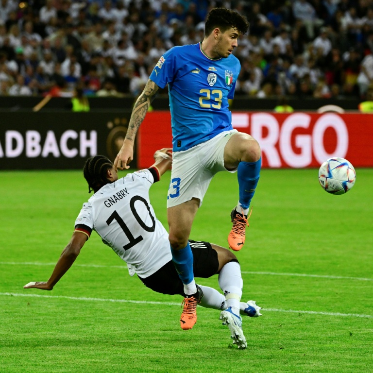 Le défenseur italien Alessandro Bastoni (d.) fait face à l'attaquant allemand Serge Gnabry (g.) lors du match de Ligue des nations entre l'Allemagne et l'Italie, à Mönchengladbach, le 14 juin 2022