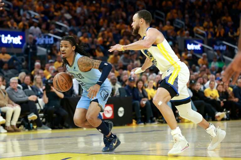 Ja Morant (g.), le meneur des Memphis Grizzlies, est suivi par Stephen Curry, le meneur des Golden State Warriors, lors d'un match de play-in de la NBA, à San Francisco, le 15 avril 2025