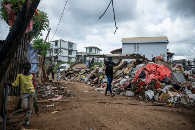 Un homme transporte des plaques de tôle dans le quartier de Cavani, à Mamoudzou, le 2 janvier 2025 à Mayotte